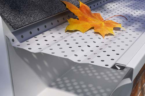 Gutter guard closeup with orange fall leaf.